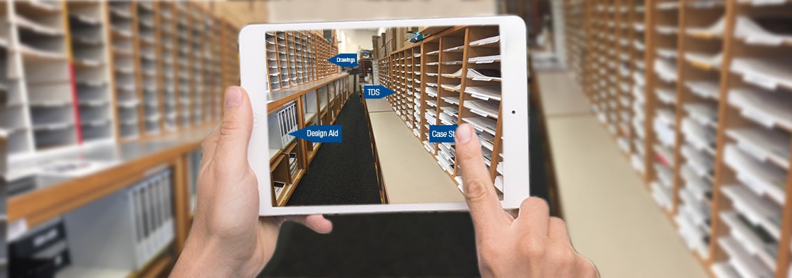 Photo of hands holding an iPad in a library of documents